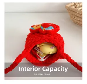 Détail montrant la capacité interne du sac rouge tricoté main avec broderie en forme de cœur