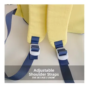 Detail of adjustable shoulder straps on yellow school backpack with blue nylon webbing