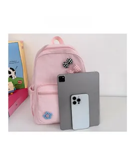 Size comparison of a pink floral school backpack with a tablet and smartphone