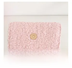 Detail showing plush pink fabric, smooth leather lining, and magnetic gold metal clasp