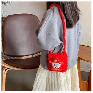 Détail d'un sac tricoté rouge pour enfants avec un personnage mignon en peluche