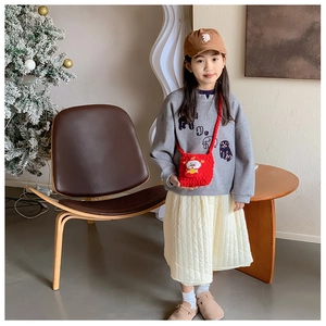 Détail d'un sac bandoulière rouge au crochet fait main avec un dieu de fortune dessin animé