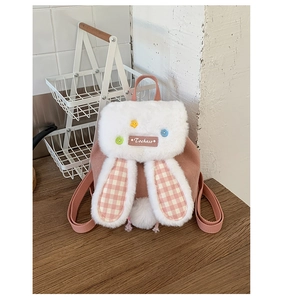 Detail of pink corduroy kids backpack with plush rabbit ears and checkered pattern