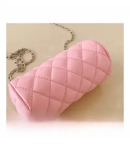 Macro shot of pink quilted cylinder bag featuring rhombus stitching and silver chain