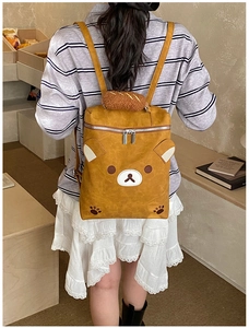 Close-up of cute yellow bear backpack with plush brown handle and detailed 3D ear design