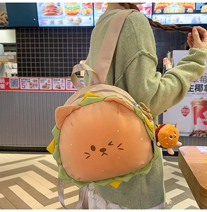 Detail of creative burger-shaped backpack with cute cat embroidery and soft plush charm