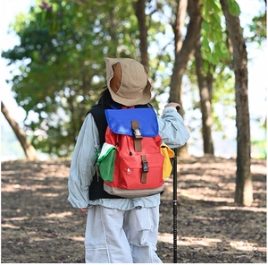 Close-up of colorful children's hiking backpack with buckles and pockets in forest setting