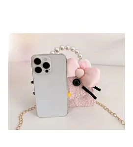 Detailed view of pink plush kitten bag with pearl handle and smartphone for size scale