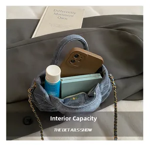 Internal capacity of blue denim quilted mini bag showing phone and cosmetics