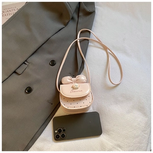 Détail du mini sac à bandoulière rose avec nœud et décor de chien pour petites filles