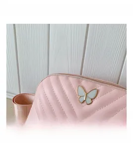 Detail of pink PU leather kids bag with V-shaped quilting and butterfly metal buckle