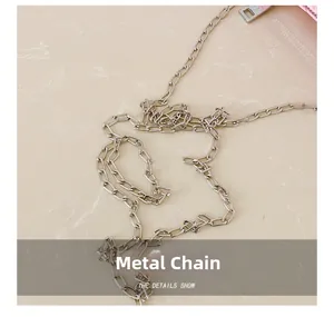 Macro view of silver metal chain strap and hardware detail on pink cylinder bag