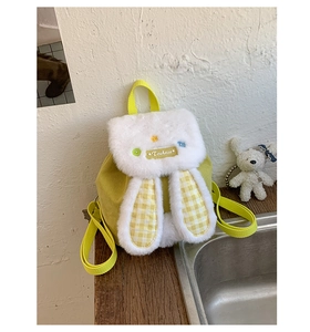 Detailed texture of yellow corduroy child backpack with plush rabbit ears and drawstring
