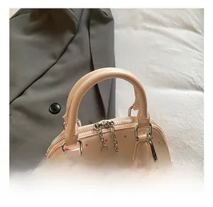 Detail der hellrosa Muschel-Tasche mit roten Punkten und Apfel-Plüsch-Anhänger