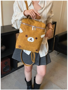 Toddler backpack with cute bear face features and plush handle shown on model