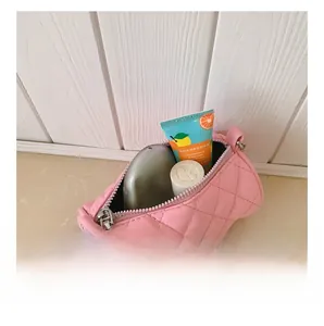 Internal storage view of pink quilted mini barrel bag for kids with chain strap
