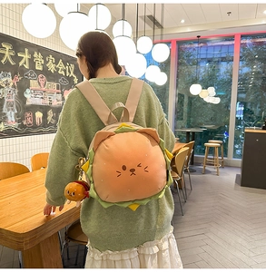 Detail view of a plush burger cat backpack with a cute mascot pendant in a cafe