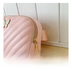Detail shot of the smooth metal zipper and quilted stitching on a pink mini bag