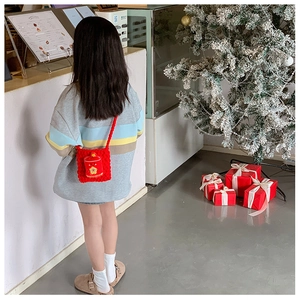 Vue détaillée d'un enfant portant un sac à bandoulière rouge crocheté de poche de chance