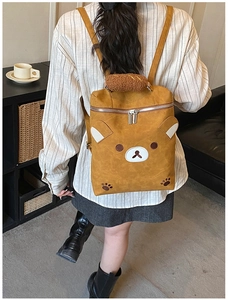 Detail view of ginger yellow bear backpack with plush handle and 3D ears shown on model