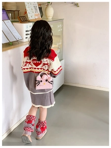 Detail of pink plush kitten bag with pearl handle worn by a girl in knitwear