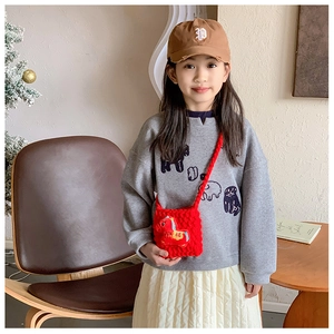 Gros plan du sac bandoulière tricoté rouge avec broderie Fu sur un mannequin enfant