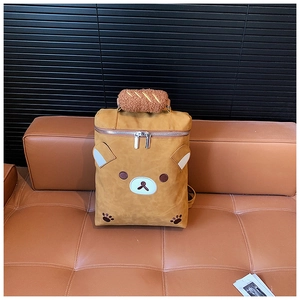 Detail view of cartoon bear backpack featuring plush bread-shaped handle and embroidery