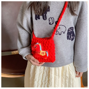 Détail du sac au crochet rouge fait main avec breloque cheval et broderie Fu dorée