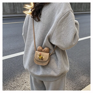 Detail of a mini khaki suede kids crossbody bag with 3D bow and cute puppy embroidery