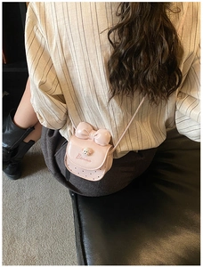 Détail du mini sac bandoulière rose avec nœud, breloque chiot et lettrage Barma