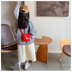 Sac bandoulière rouge au crochet pour enfant avec poney en peluche sur fond chaleureux