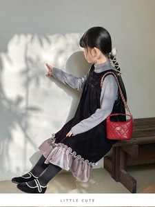 Détail de la robe en velours pour enfant avec ourlet à volants et tissu texturé élégant
