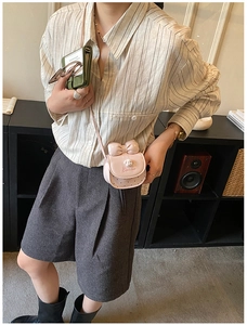 Détail du mini sac rose avec nœud, pendentif ours et motifs de cœurs découpés