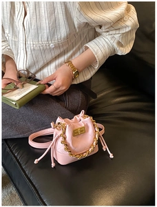 Vue détaillée du mini sac seau matelassé rose avec bandoulière chaîne et fermoir pivot