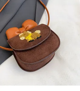 Detail of child crossbody bag with orange leather bow and plush puppy embroidery