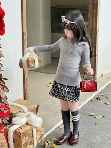 Herbstliches Outfit für Mädchen mit grauem Pullover, Leopardenrock und roter Handtasche