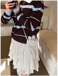 Détail du mini sac bandoulière en cuir blanc avec gros nœud et breloques de dessin animé