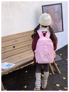 Pink waterproof nylon kids backpack with drawstring detail shown in an outdoor setting