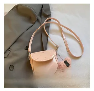 Détail du sac bandoulière rose en similicuir avec broderie cœur et breloque peluche