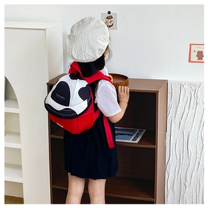 Close-up of cute red kids backpack with cow print pocket worn by a toddler girl