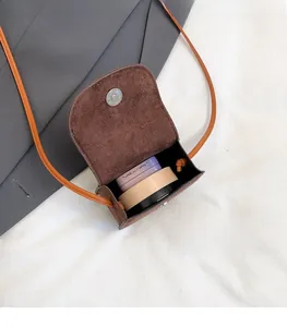Detail view of the brown suede mini crossbody bag showing internal capacity and magnetic closure