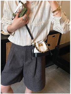 Détail d'un mini sac seau matelassé noir et blanc avec chaîne dorée et cordon