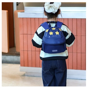 Detail of navy blue kids backpack with yellow star patterns and breathable mesh pocket