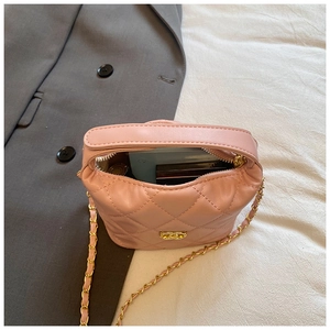 Détail d'un sac bandoulière matelassé rose montrant sa capacité et sa chaîne dorée
