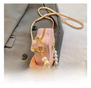 Pink glitter mini square bag featuring gold zipper and elegant pearl handle detail