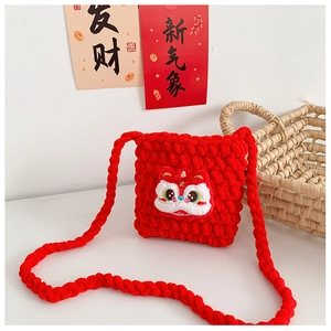 Détail macro du sac bandoulière rouge tricoté main avec broderie danse du lion