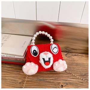 Close-up of red plush rabbit bag with pearl handle and golden chain strap for girls