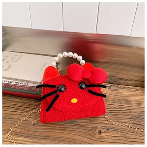 Detailed view of red plush cat bag with faux pearl handle and gold chain strap