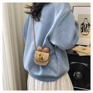 Detail of a beige mini girl's crossbody bag with a large bow and sheep embroidery