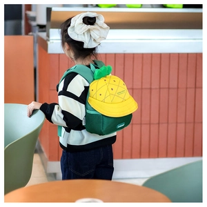 Detail view of the yellow pineapple kid's backpack with green leaves and mesh shoulder straps